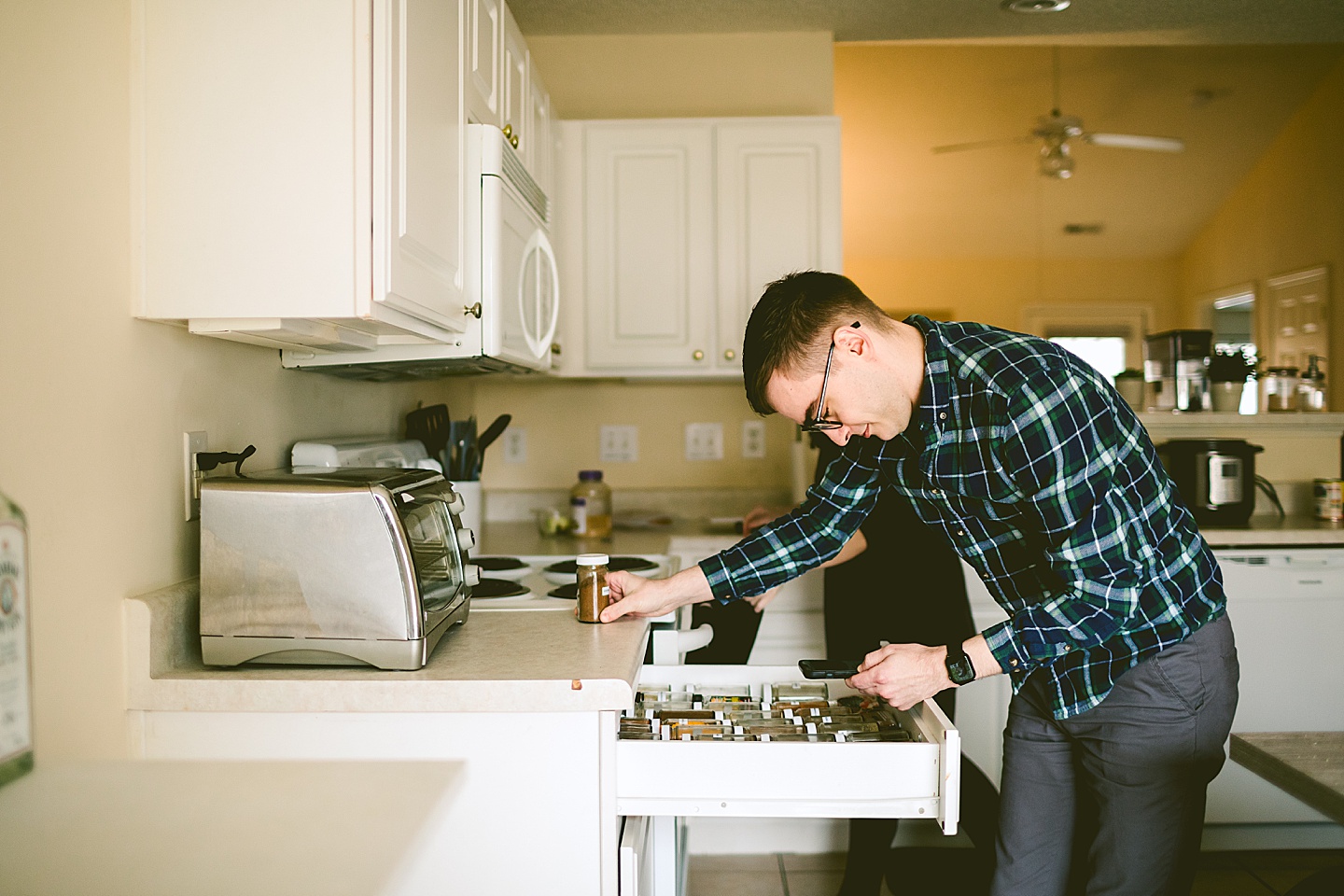 Husband looking through spice drawer in kitchen