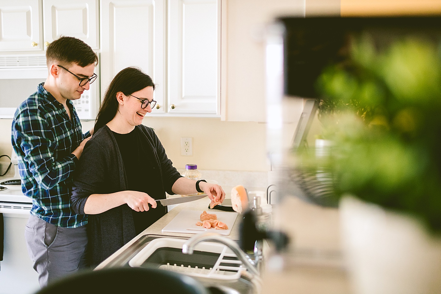 Couple making dinner together in kitchen at their home