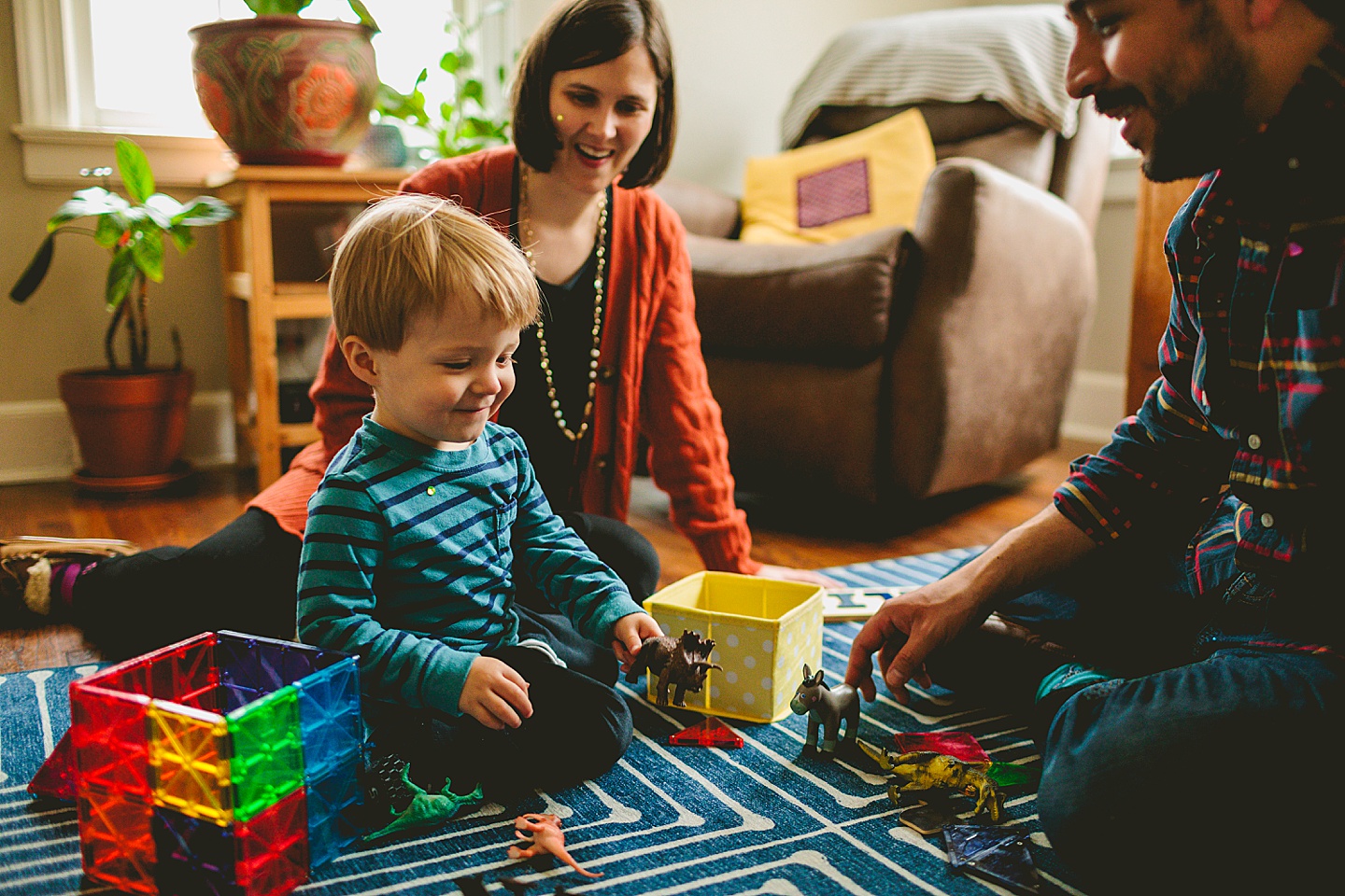 Kid holding a dinosaur on living room floor