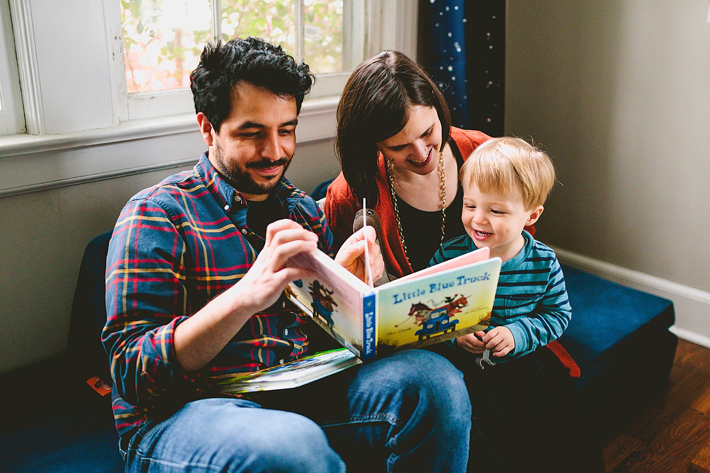 Family photo of mom and dad reading to son