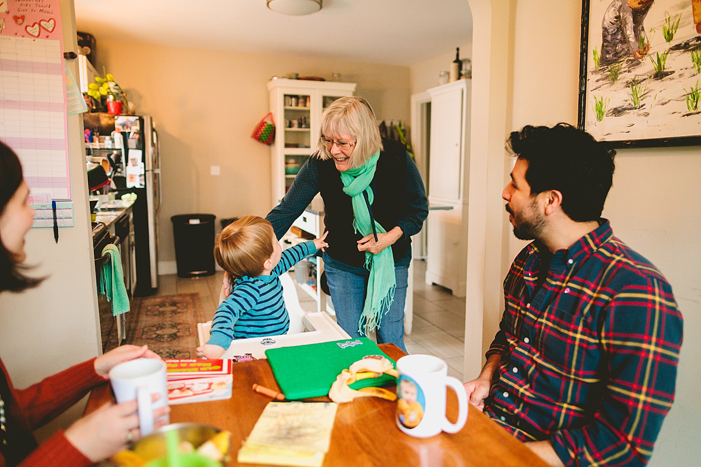 Toddler's grandma arrives to greet him in the kitchen