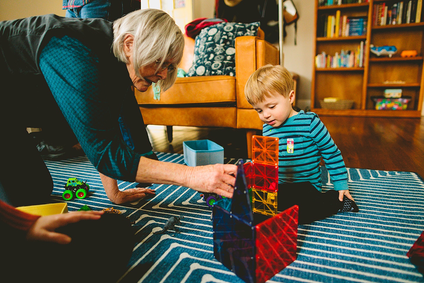 Grandma helps grandson build a tower of blocks