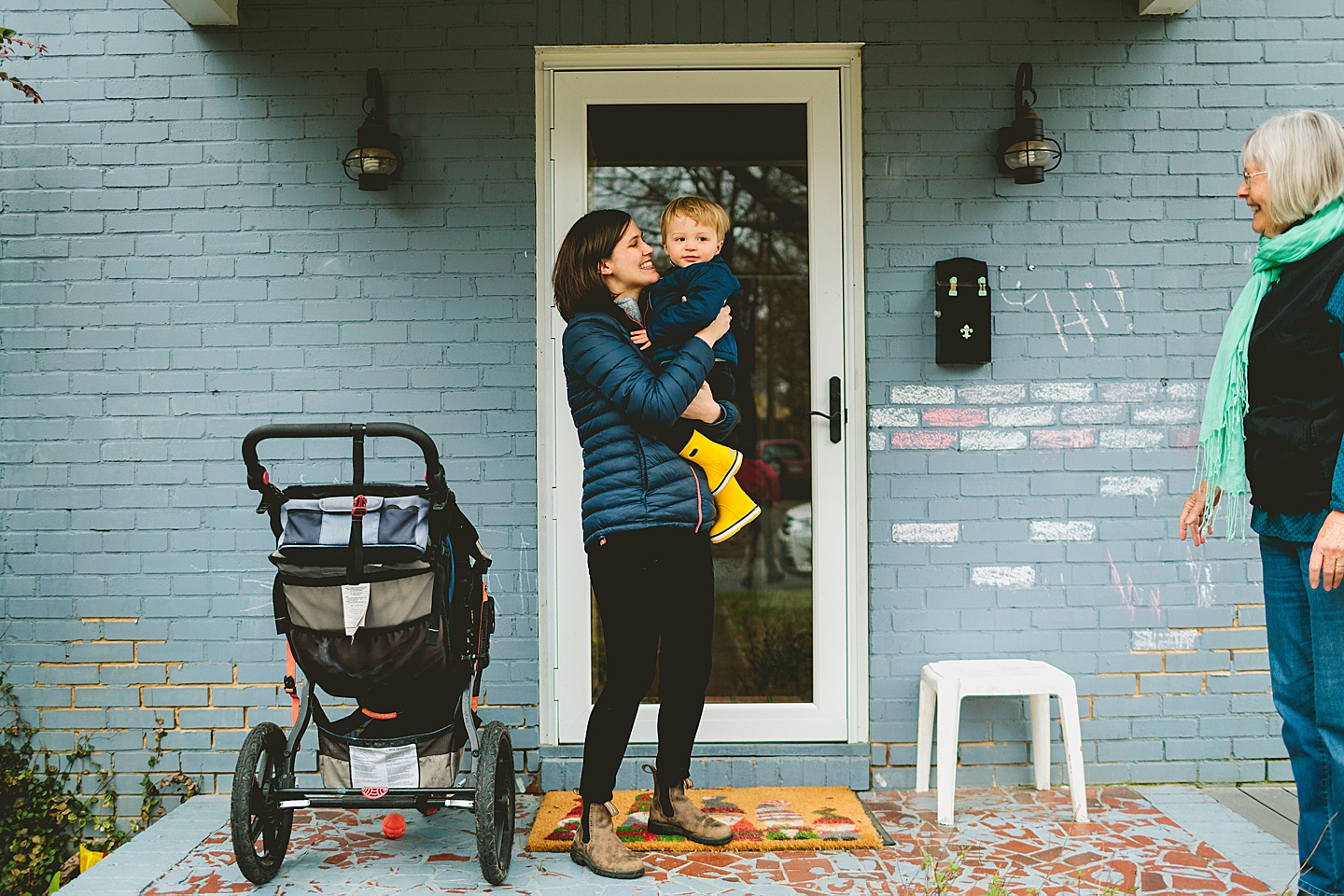 Mom holding kid outside house