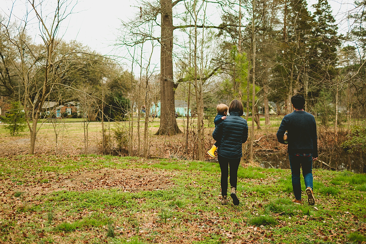 Parents walking with son to the pond in the neighborhood park