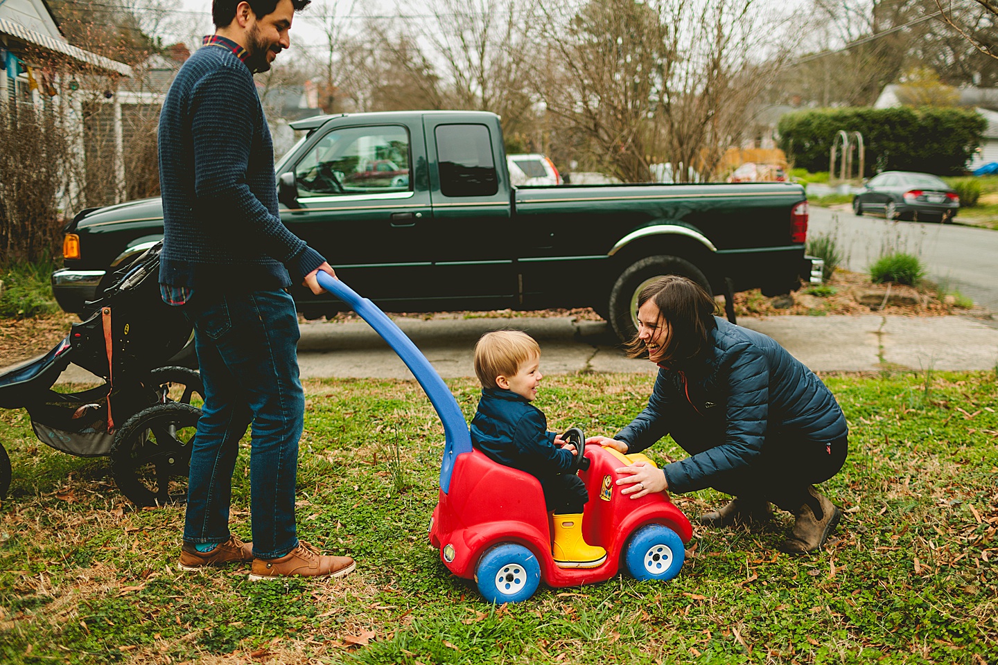 Family playing outside in Durham with toy car