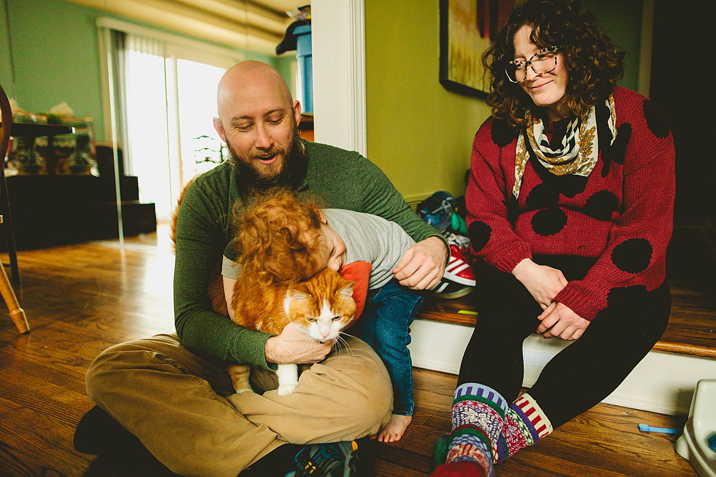 Family portrait with cat in home where boy is hugging cat