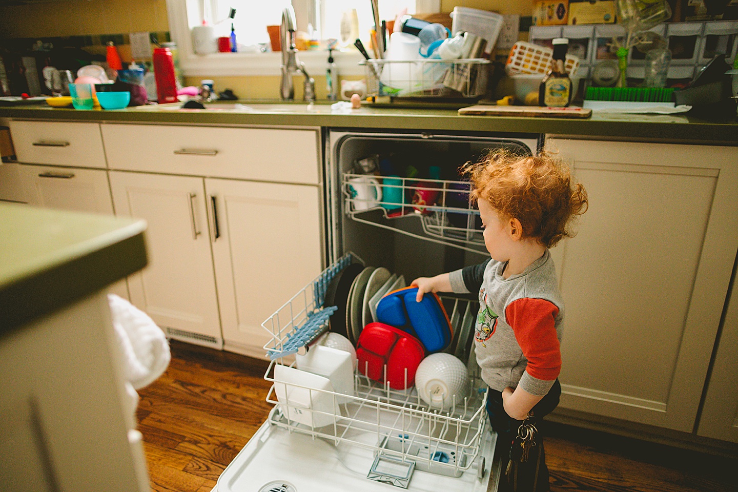 Toddler unloading dishwasher