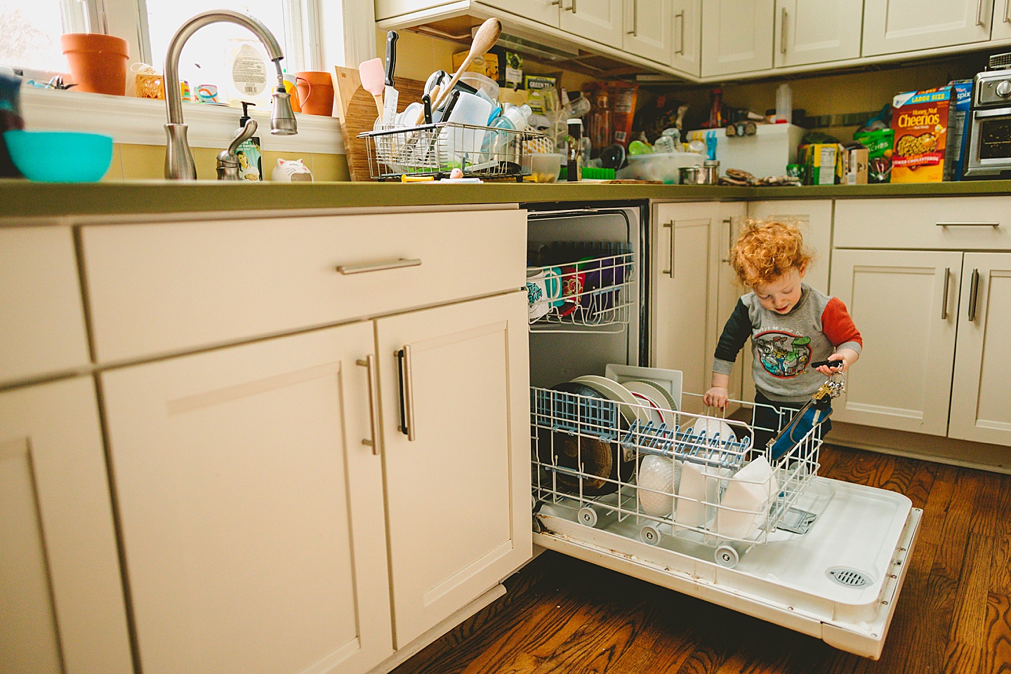 Toddler unloading dishwasher