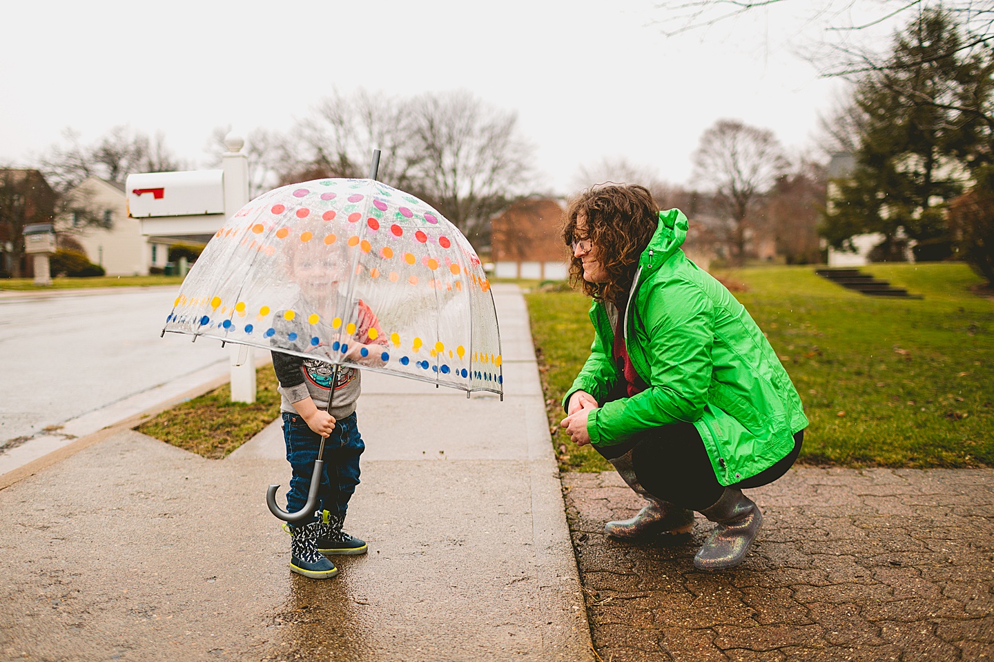 Toddler walking around with umbrella in the rain