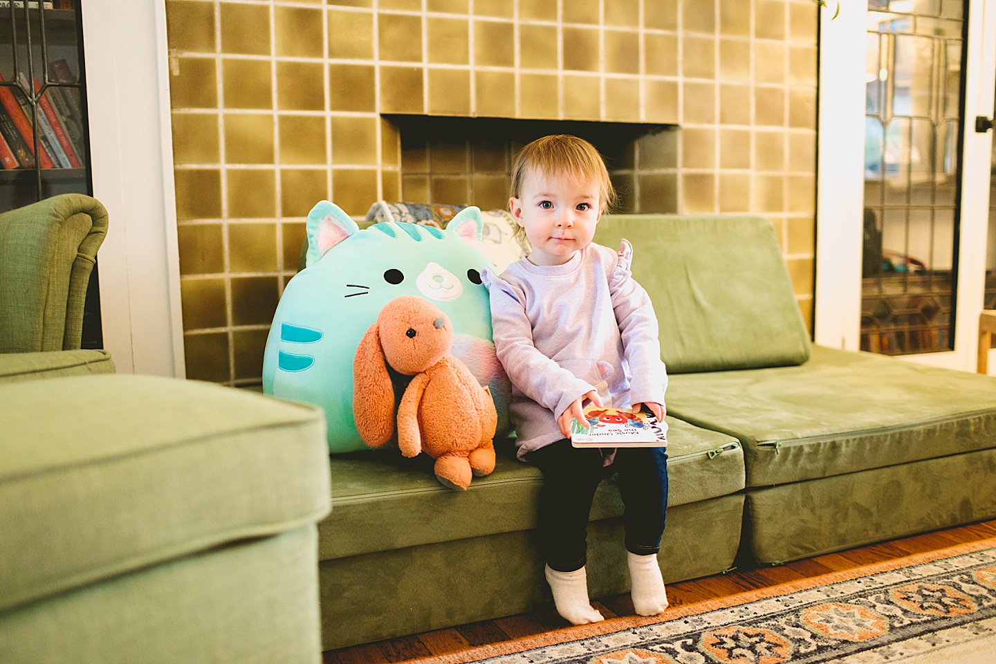toddler sitting on couch holding a book
