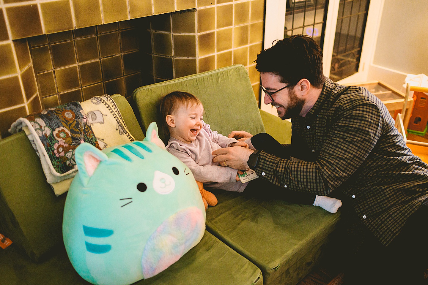 dad tickling toddler and laughing