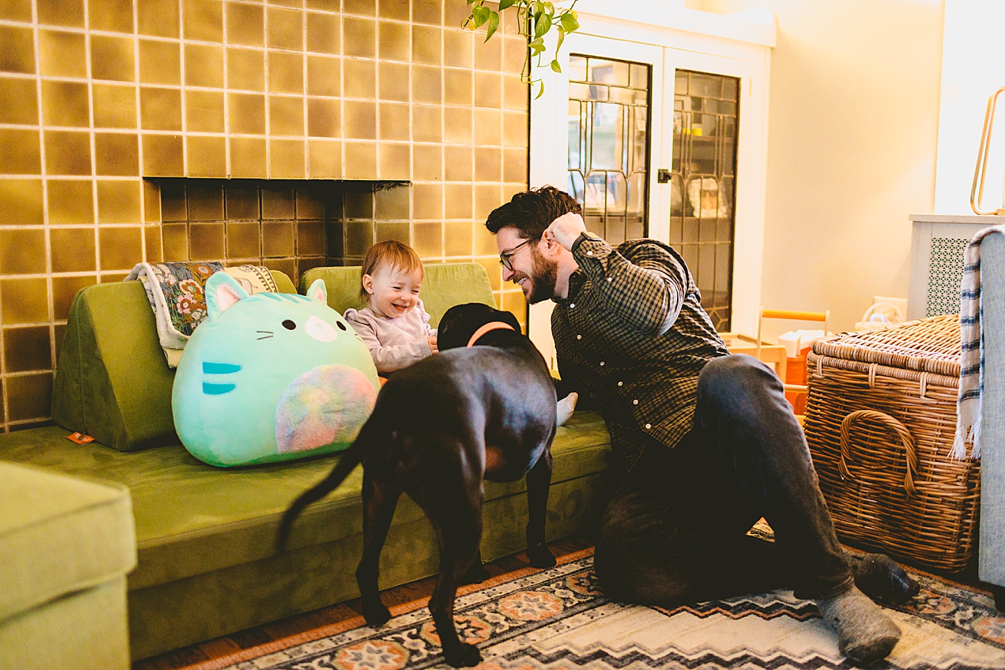 dad and daughter at home with black dog