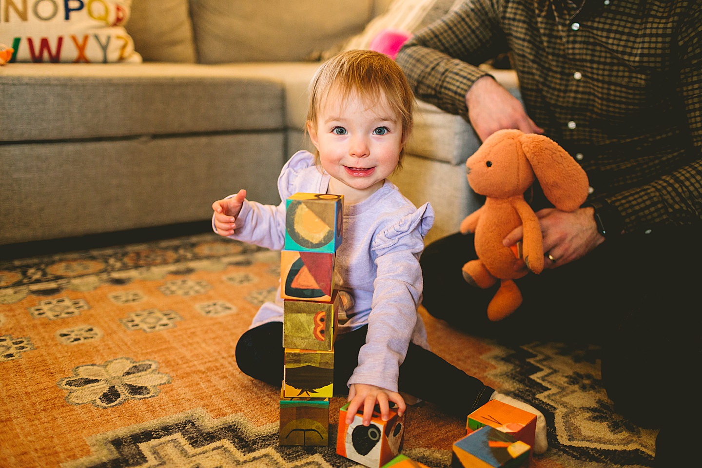 girl stacking blocks in living room