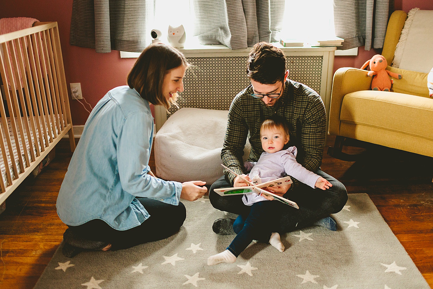 parents reading a picture book with toddler
