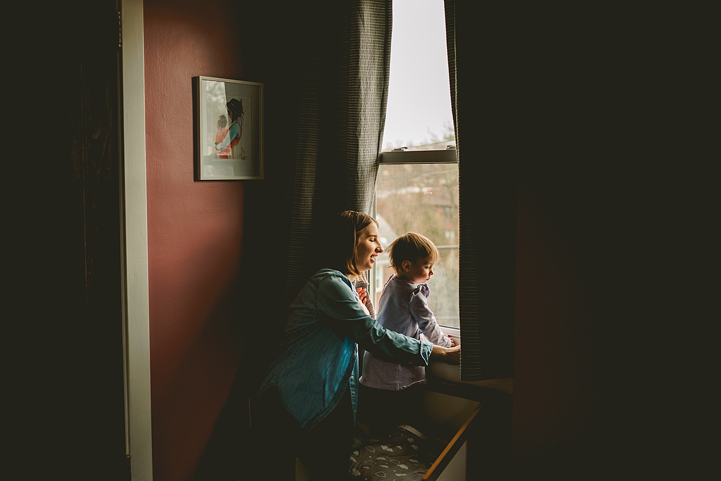 mom and daughter looking out window in pittsburgh