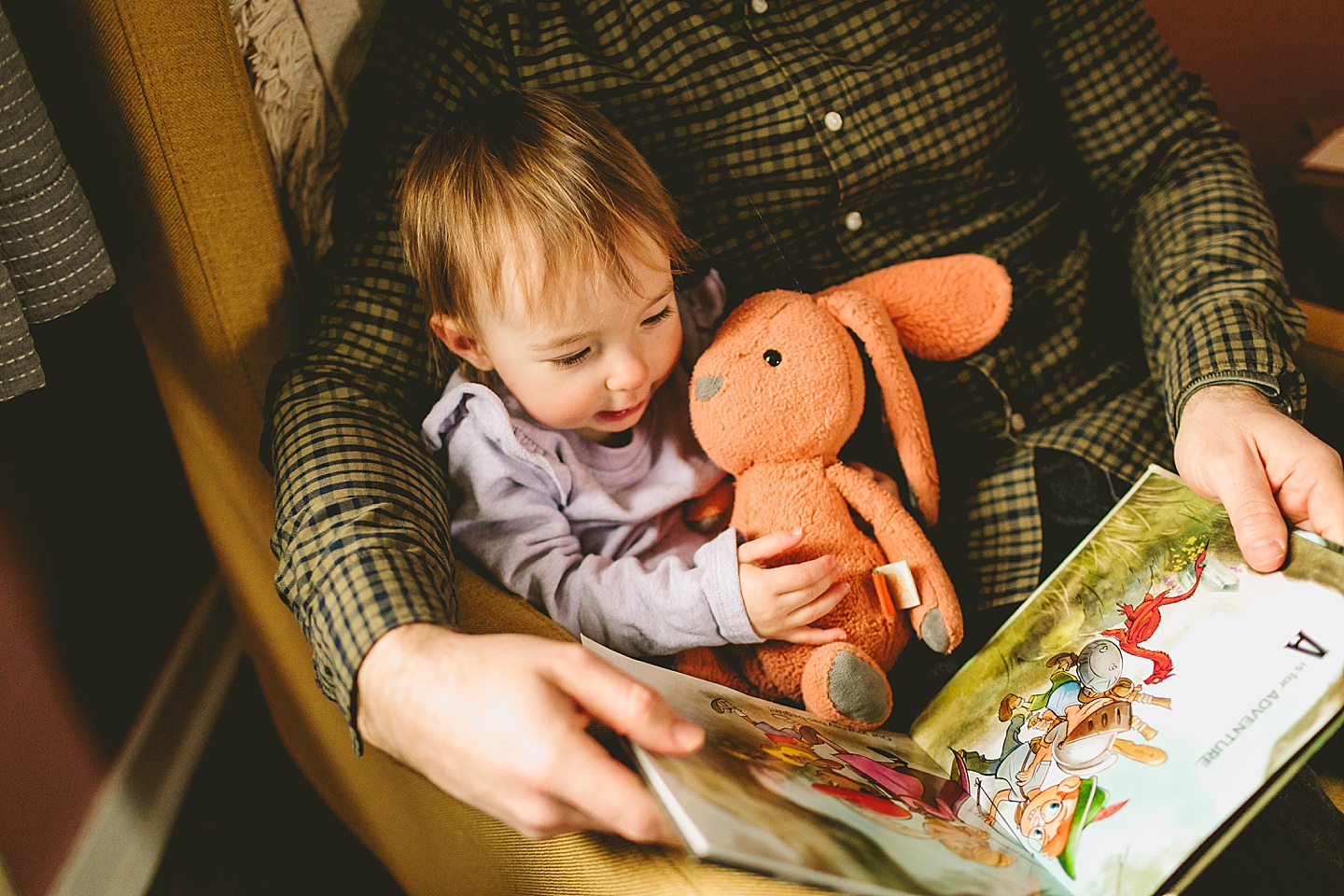 dad reading a book to his daughter