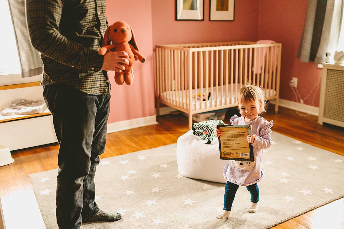 little girl carrying book around house