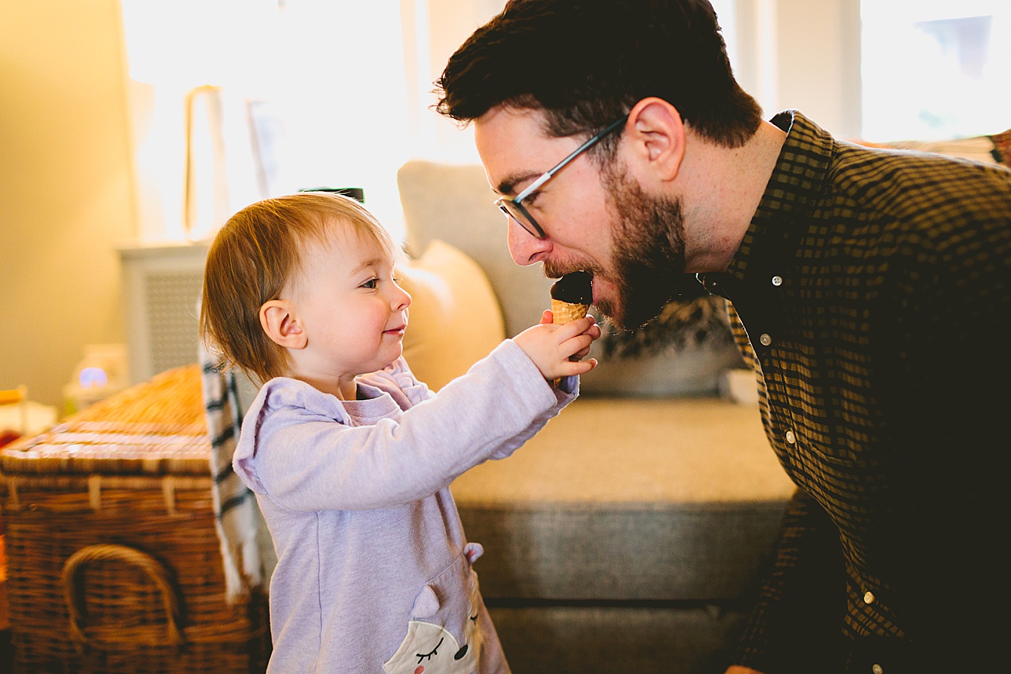 girl offering ice cream cone to dad