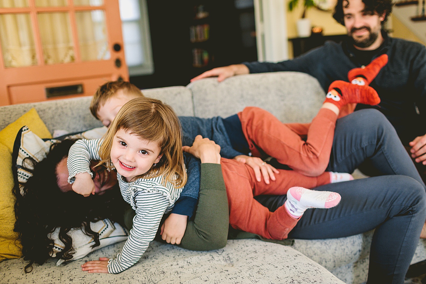 Mom wrestling with kids on the couch