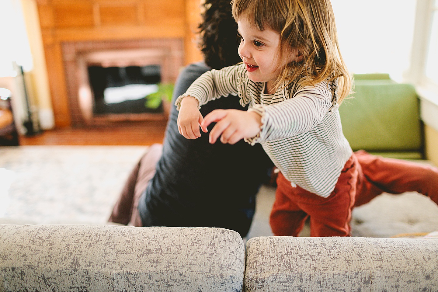 Girl laughing and running across couch