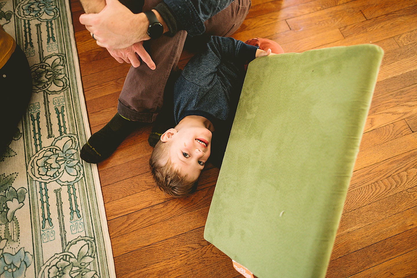 Kid holding green couch cushion