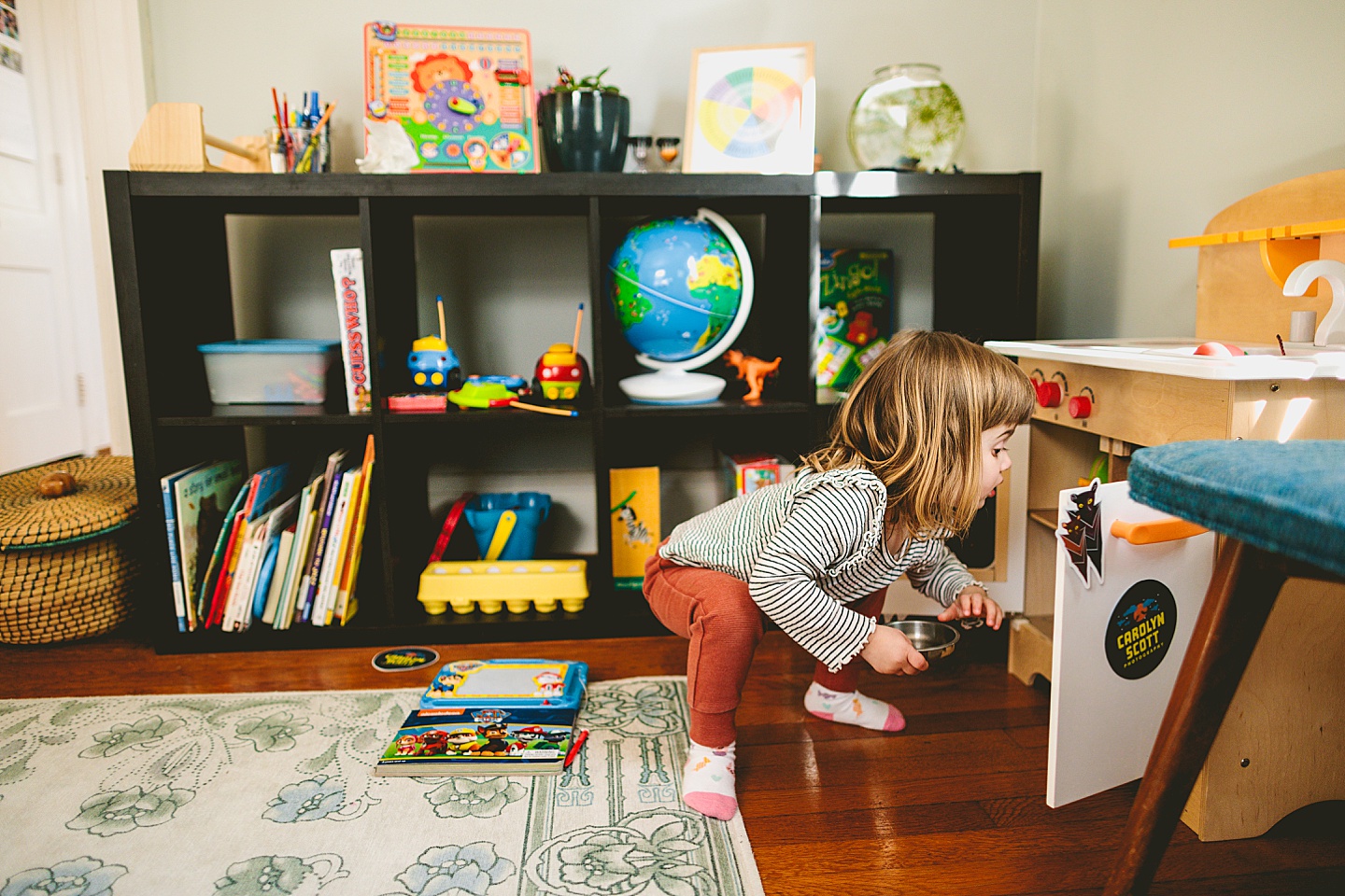 Girl working in pretend play kitchen at home