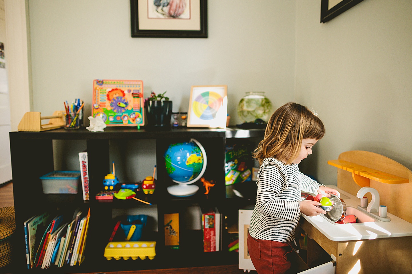 Girl working in pretend play kitchen at home