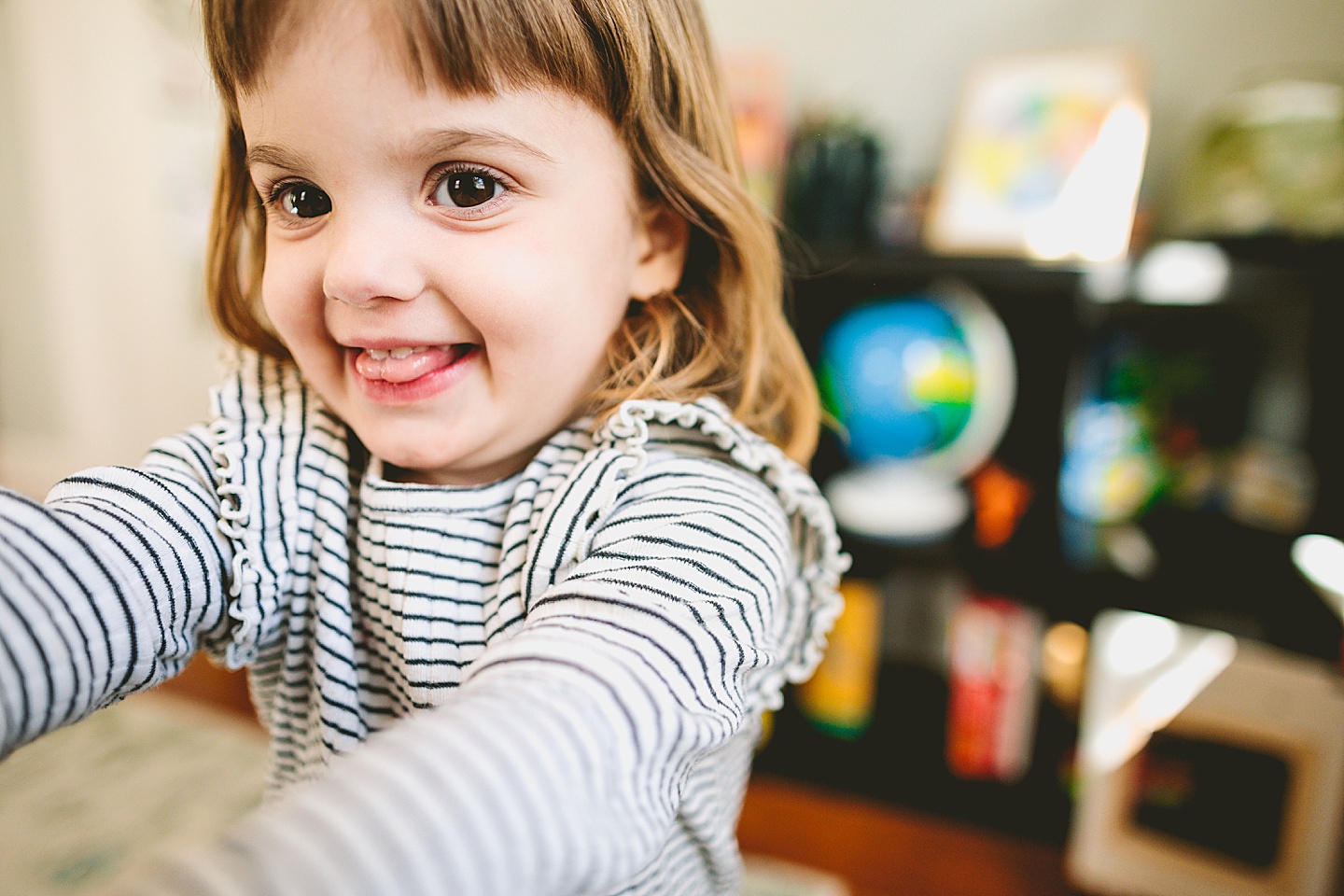 Girl smiling and holding out food from kitchen