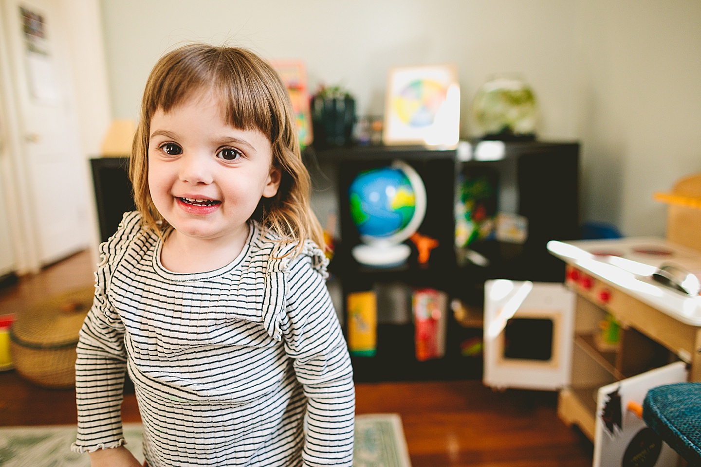 Girl smiling and holding out food from kitchen