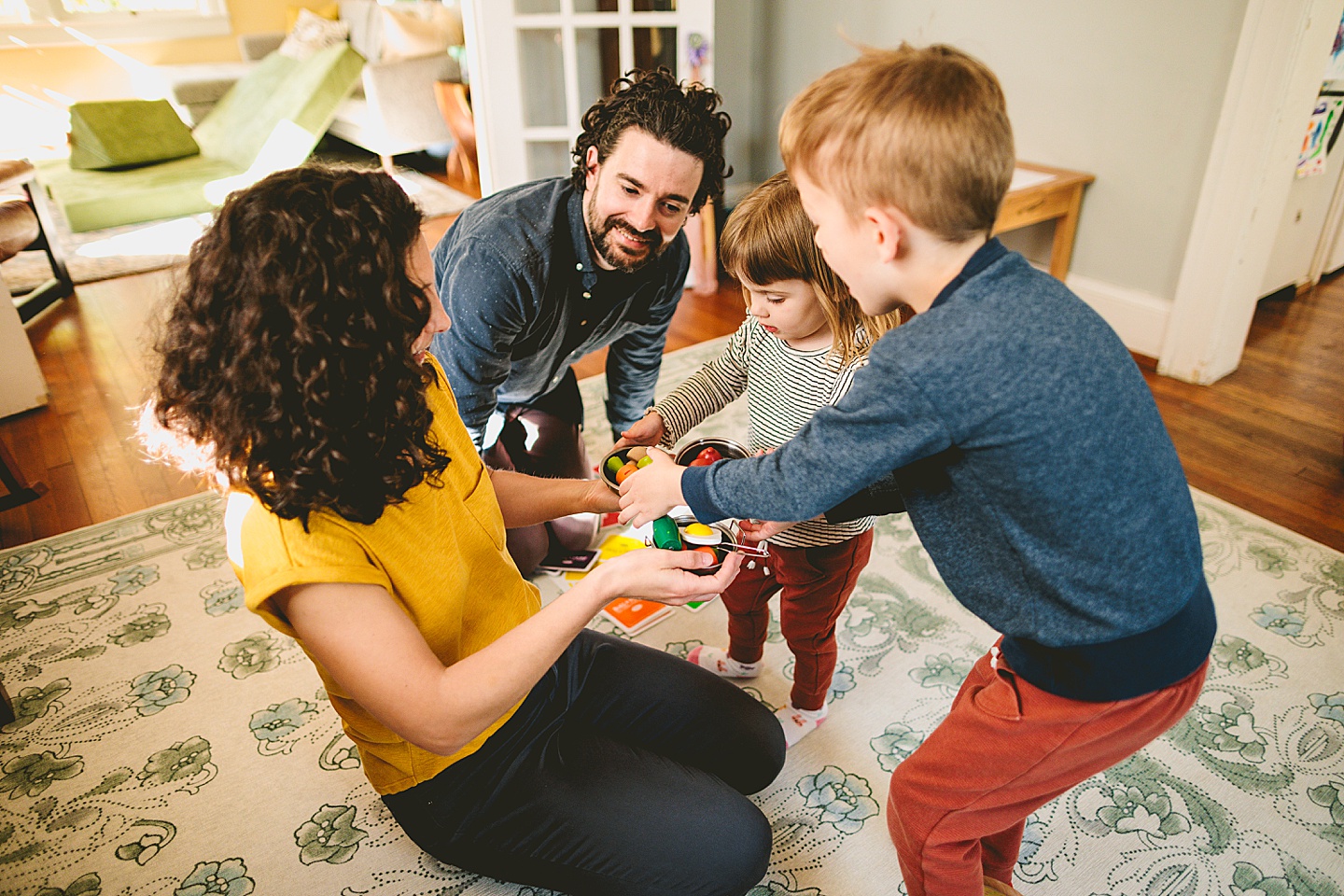 Kids offering pretend play food to parents