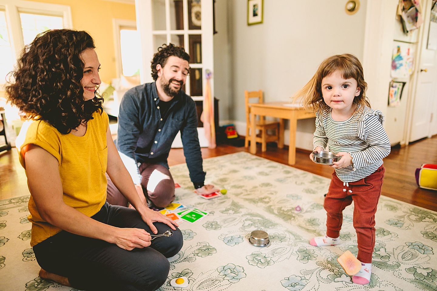 Kids offering pretend play food to parents