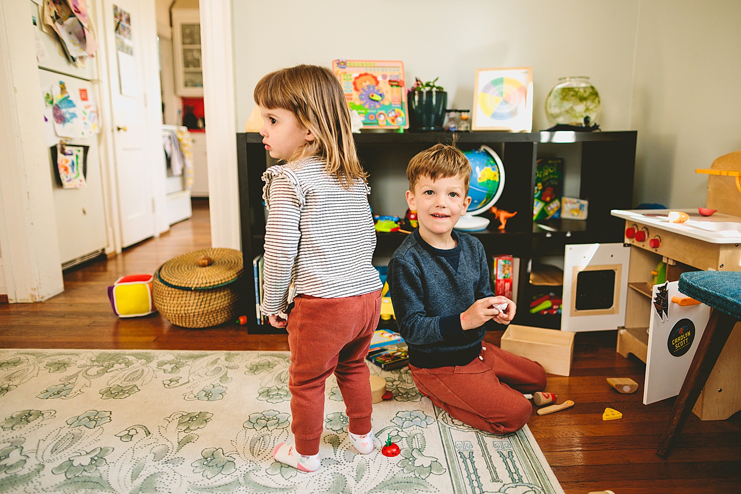 Siblings playing together in kitchen