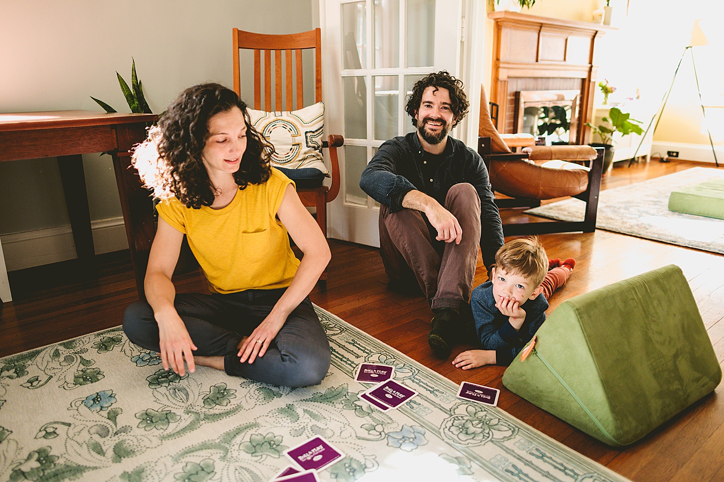 Parents sitting with son on the floor in living room