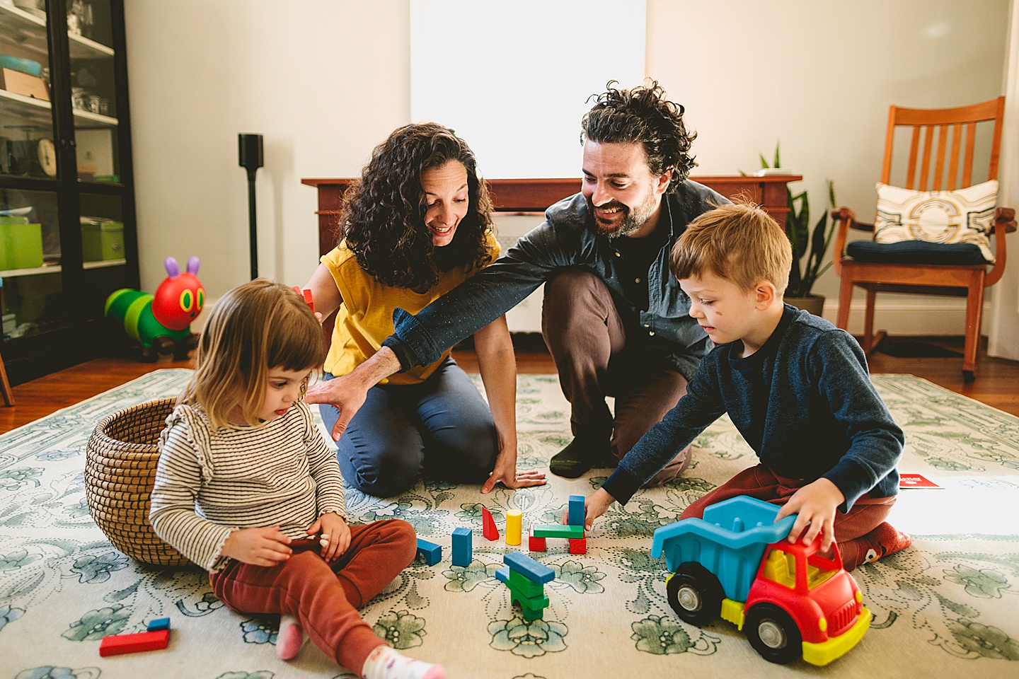 Parents building blocks with their kids on the floor during family pictures