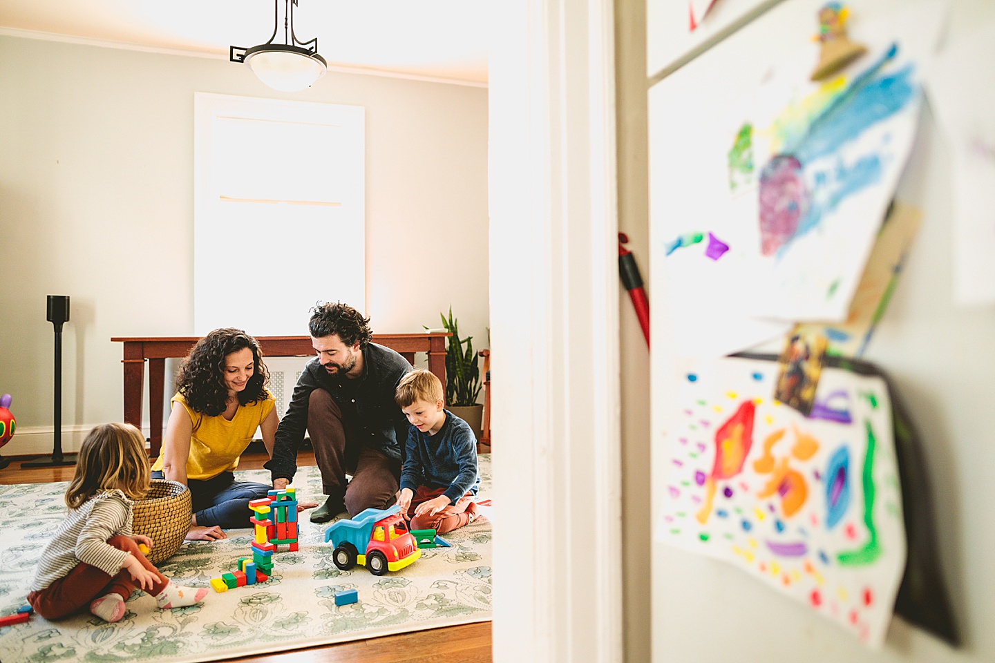 Parents building blocks with their kids on the floor during family pictures