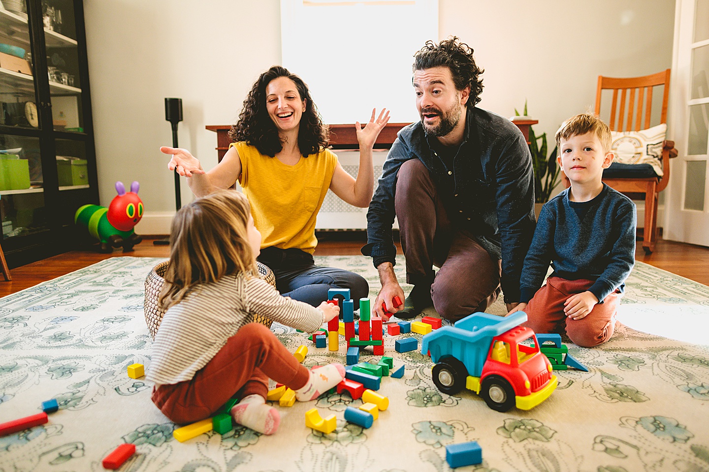 Parents building blocks with their kids on the floor during family pictures