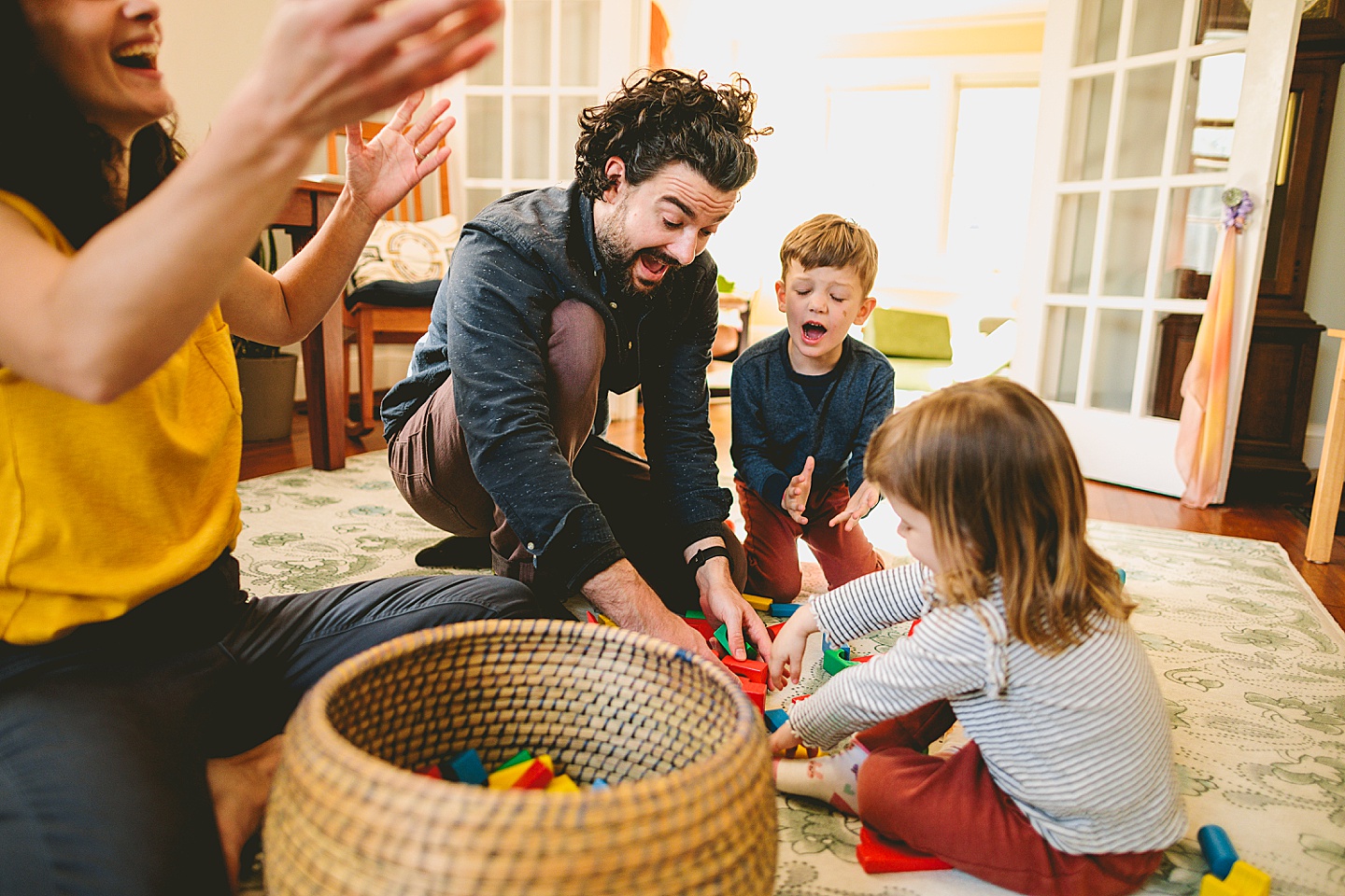 Parents building blocks with their kids on the floor during family pictures