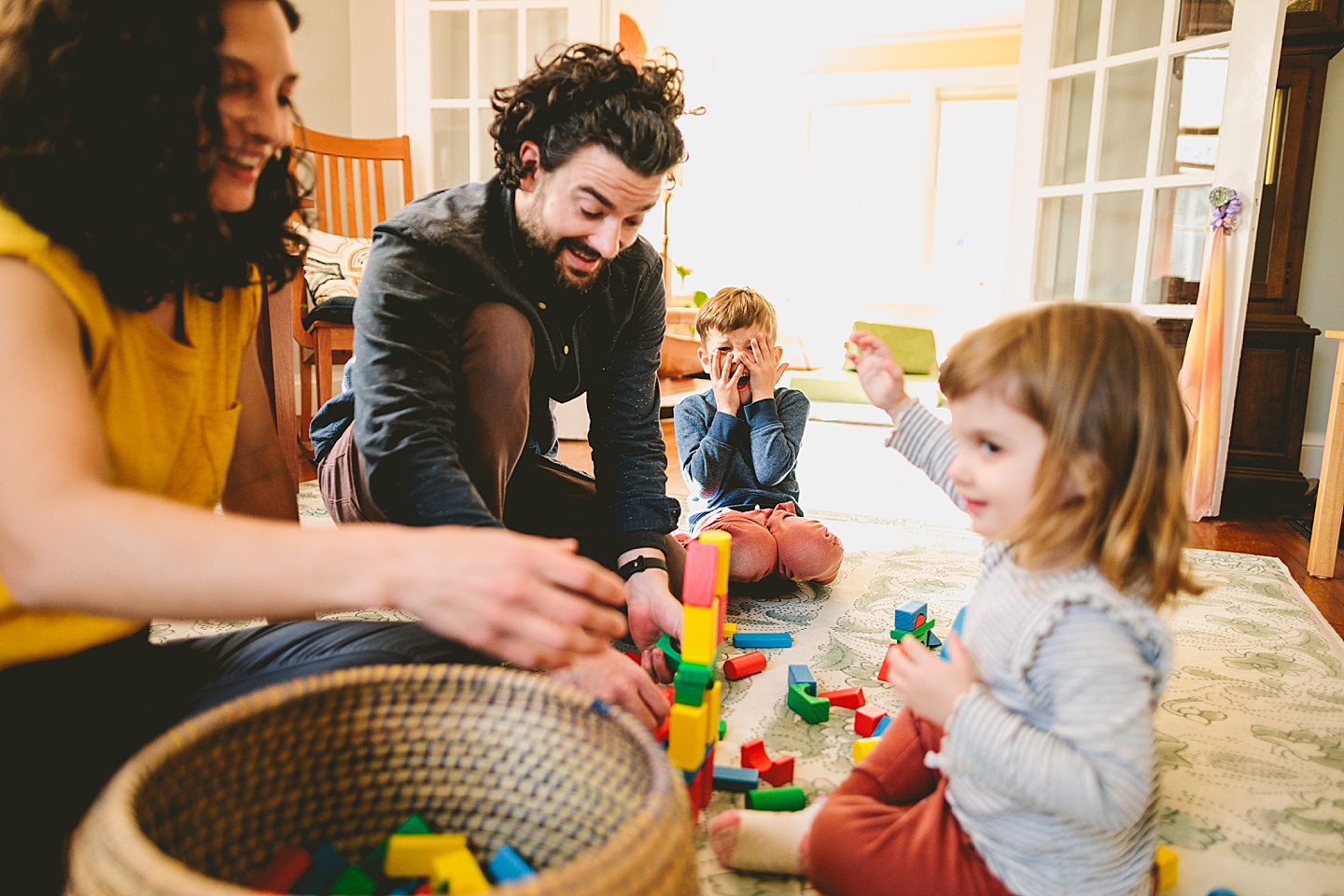 Parents building blocks with their kids on the floor during family pictures