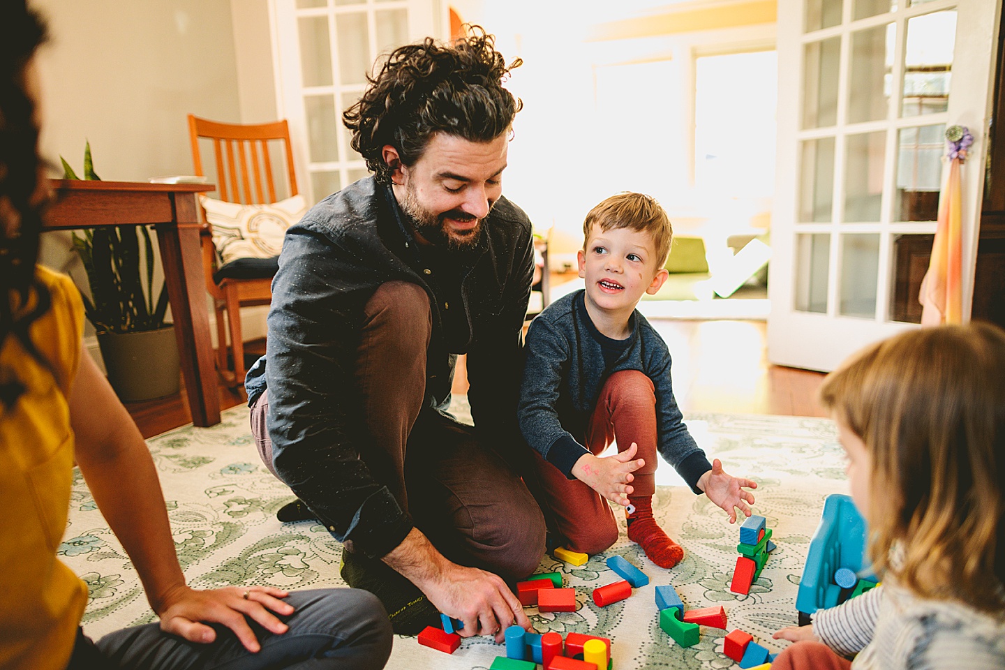 Parents building blocks with their kids on the floor during family pictures