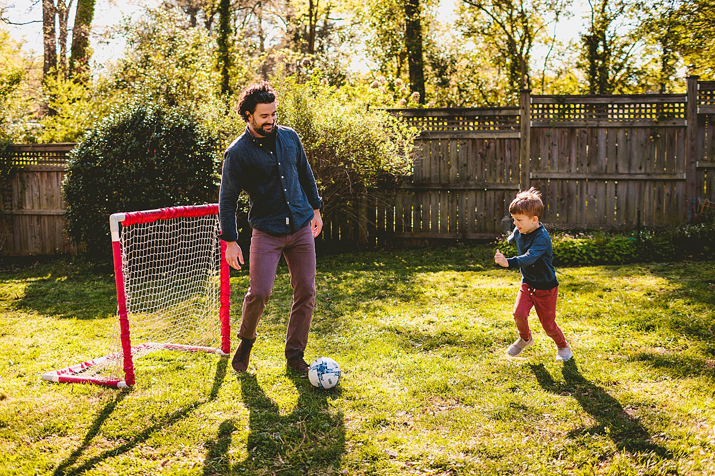 Boy playing soccer in the yard with Dad in Durham