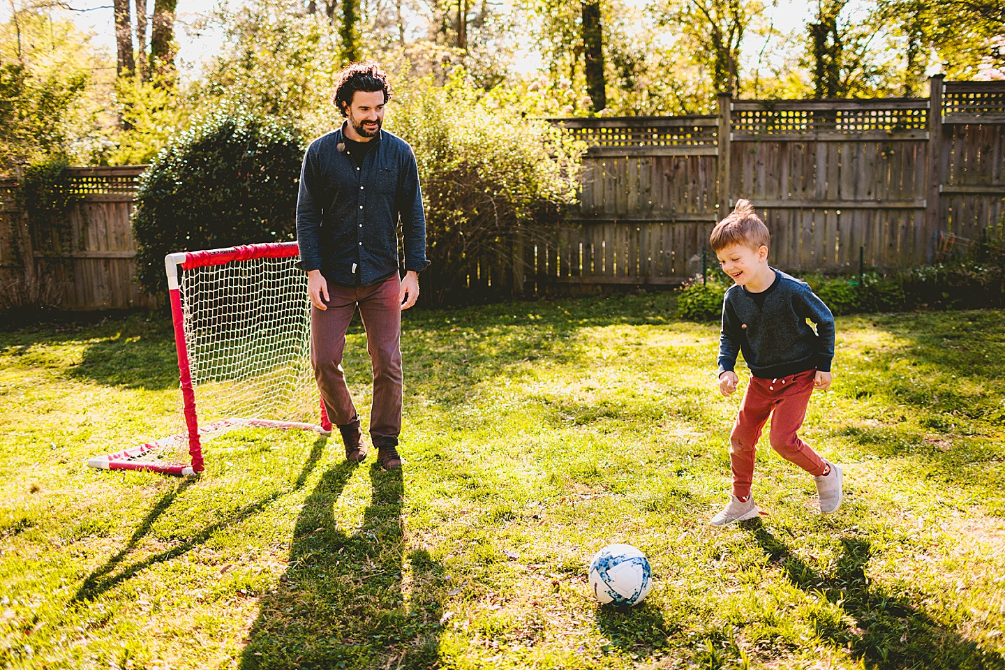 Boy playing soccer in the yard with Dad in Durham