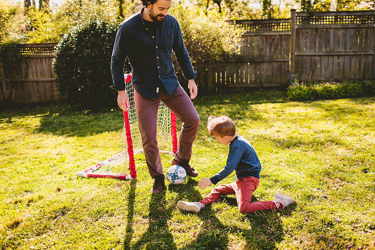 Boy playing soccer in the yard with Dad in Durham