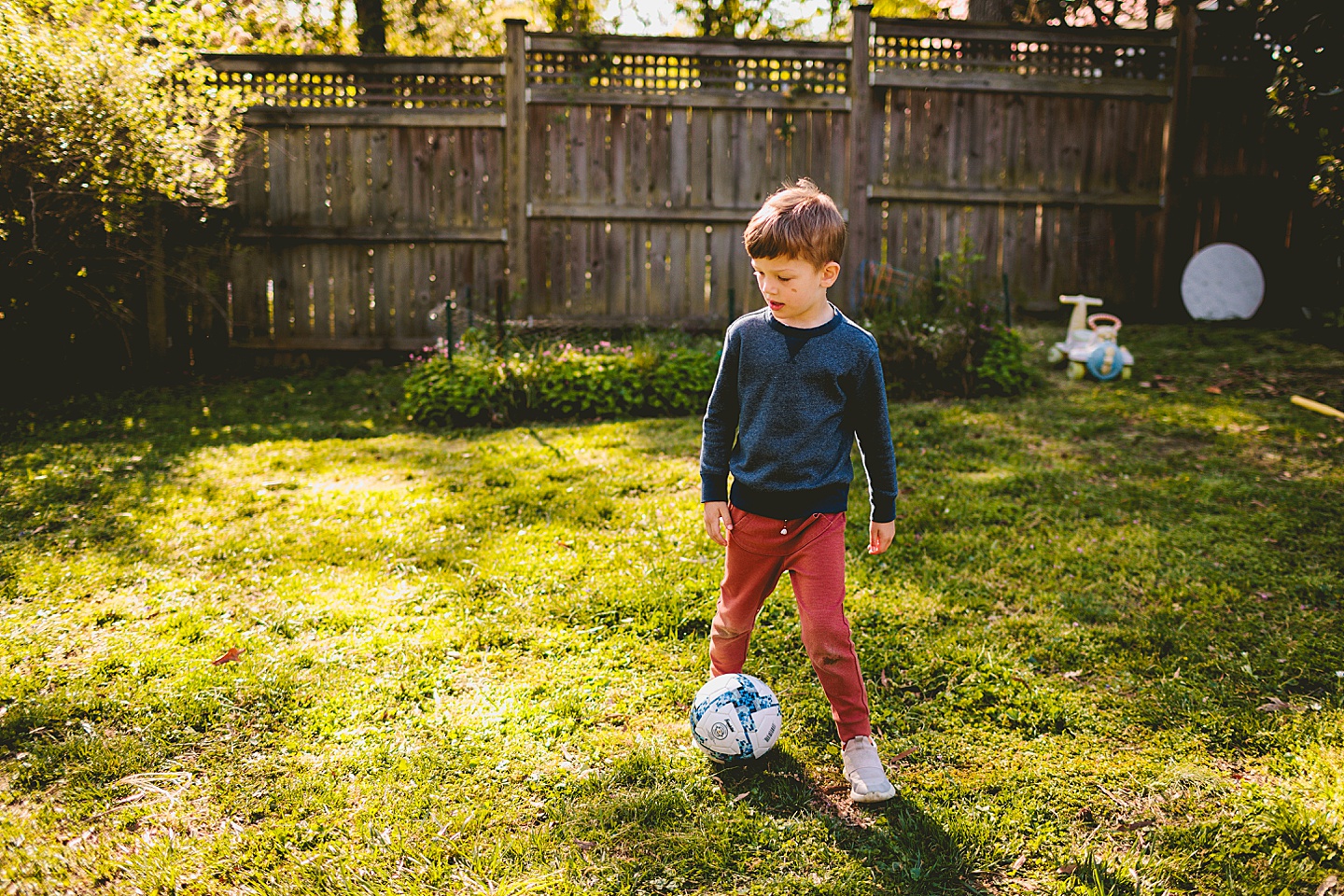 Boy playing soccer in the backyard