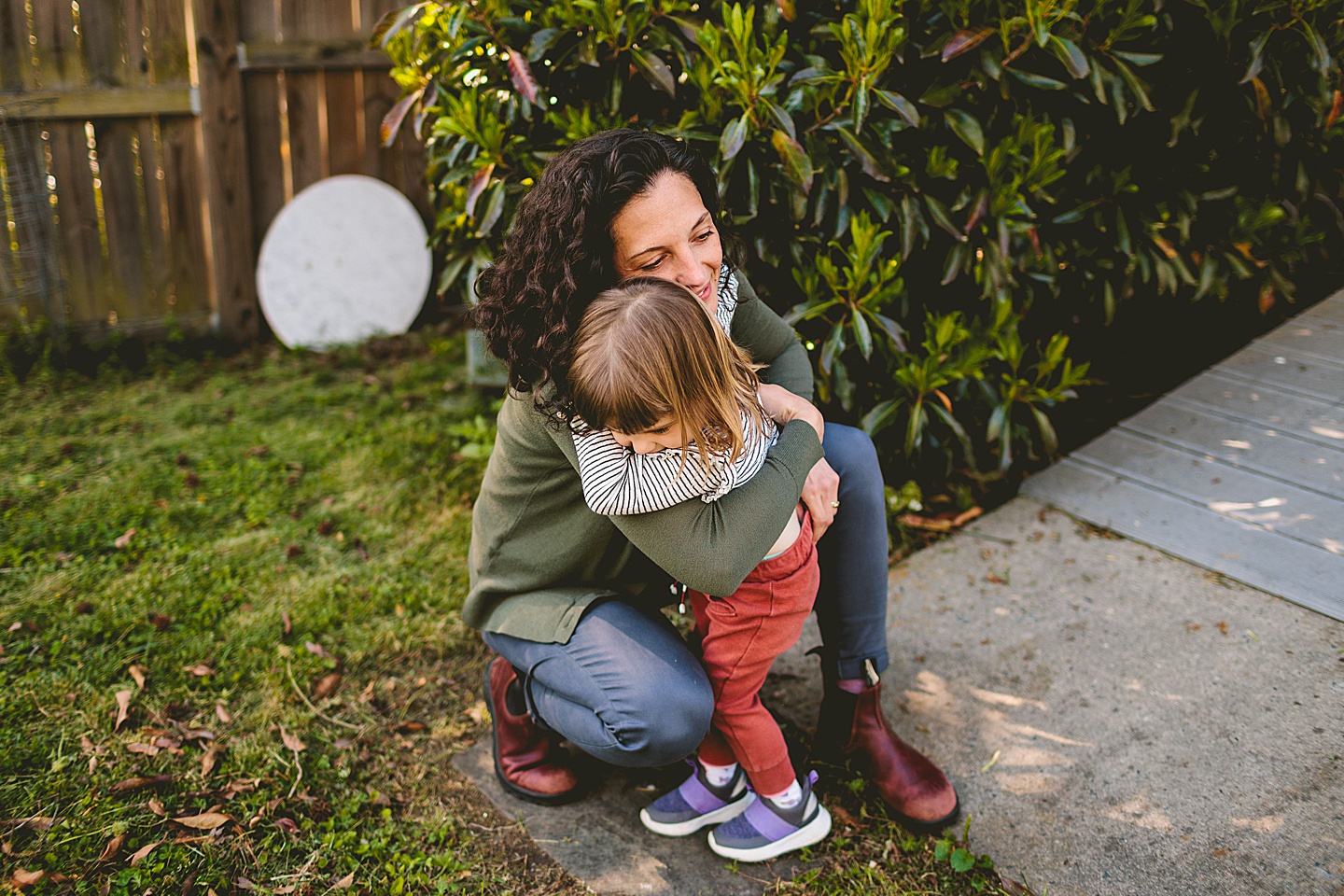 Mom hugging daughter in the yard