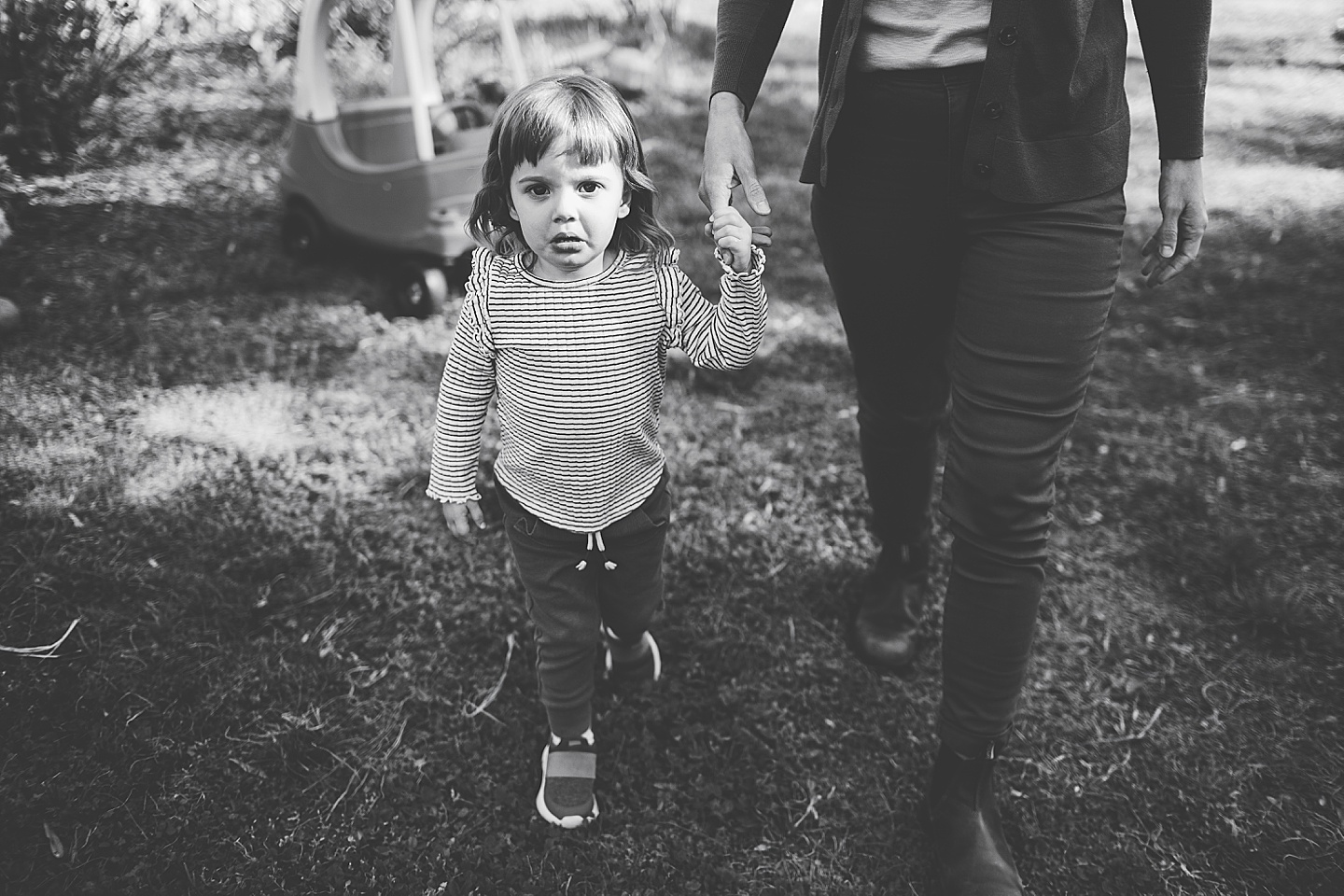 Girl crying and holding hands with mom in the backyard