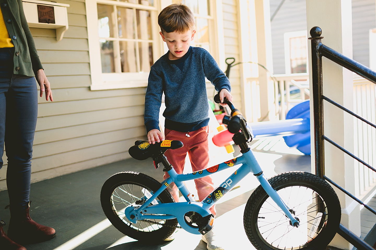 Boy holding his blue bike with stickers