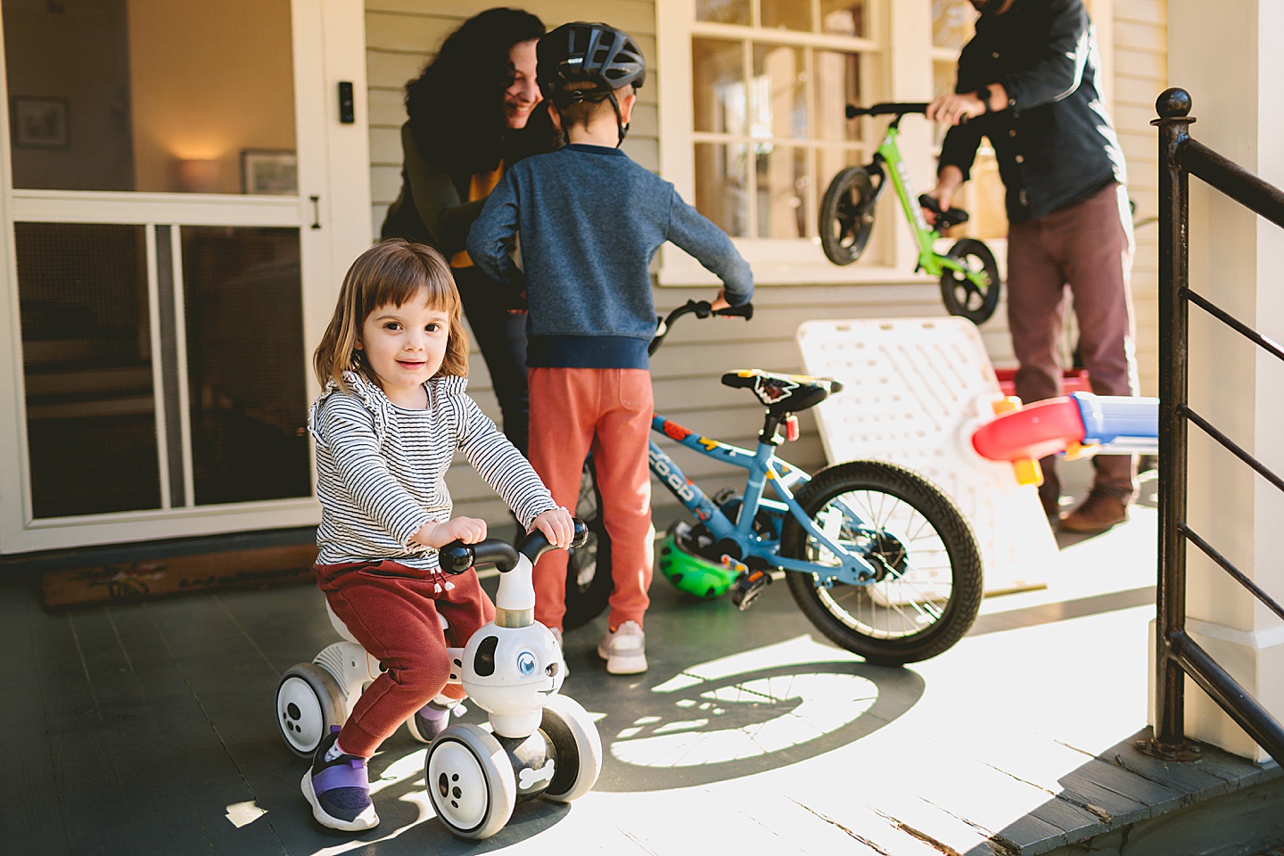 Girl sitting on her puppy bike and waiting for her family to get ready