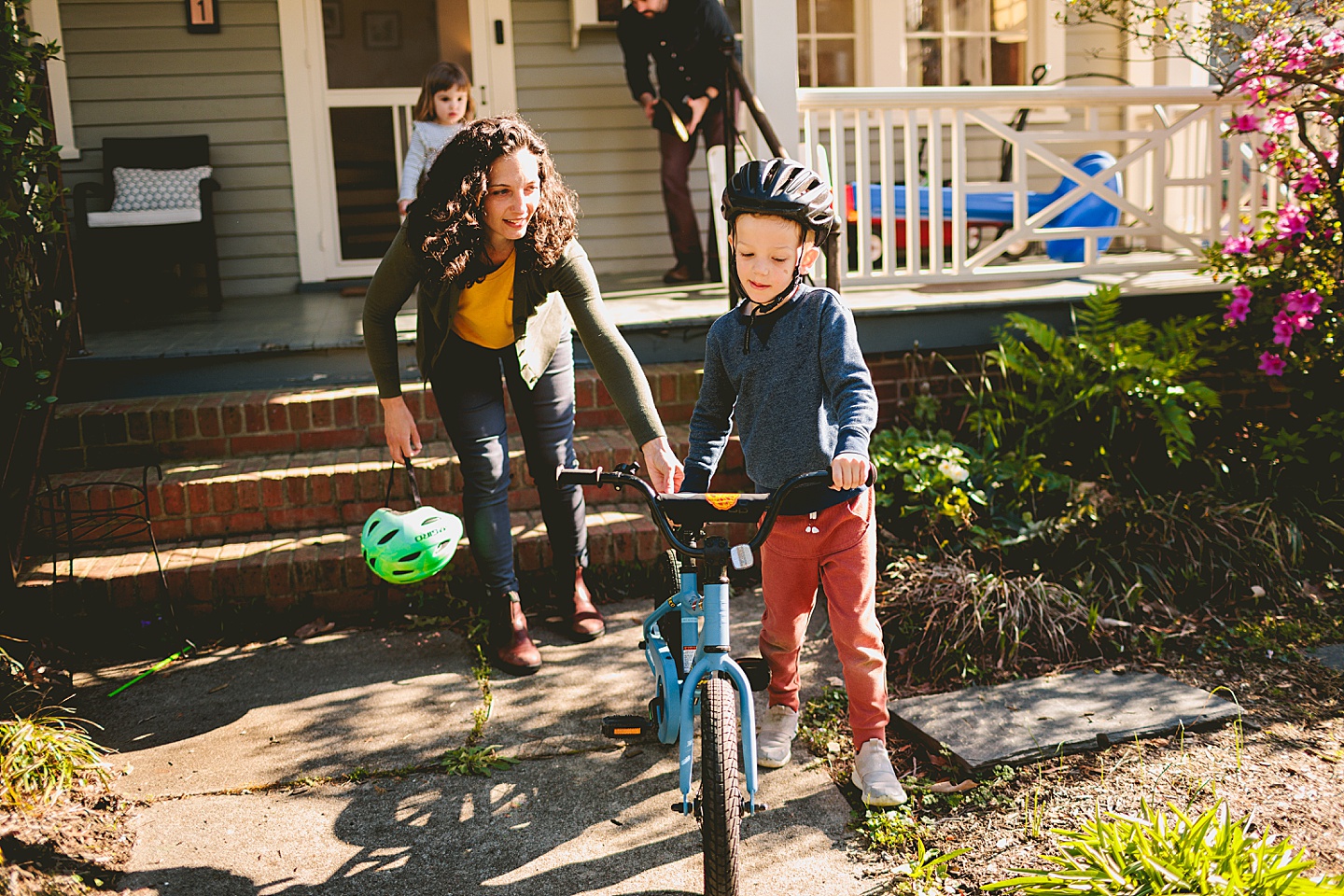 Boy carrying his bike down the steps of his house