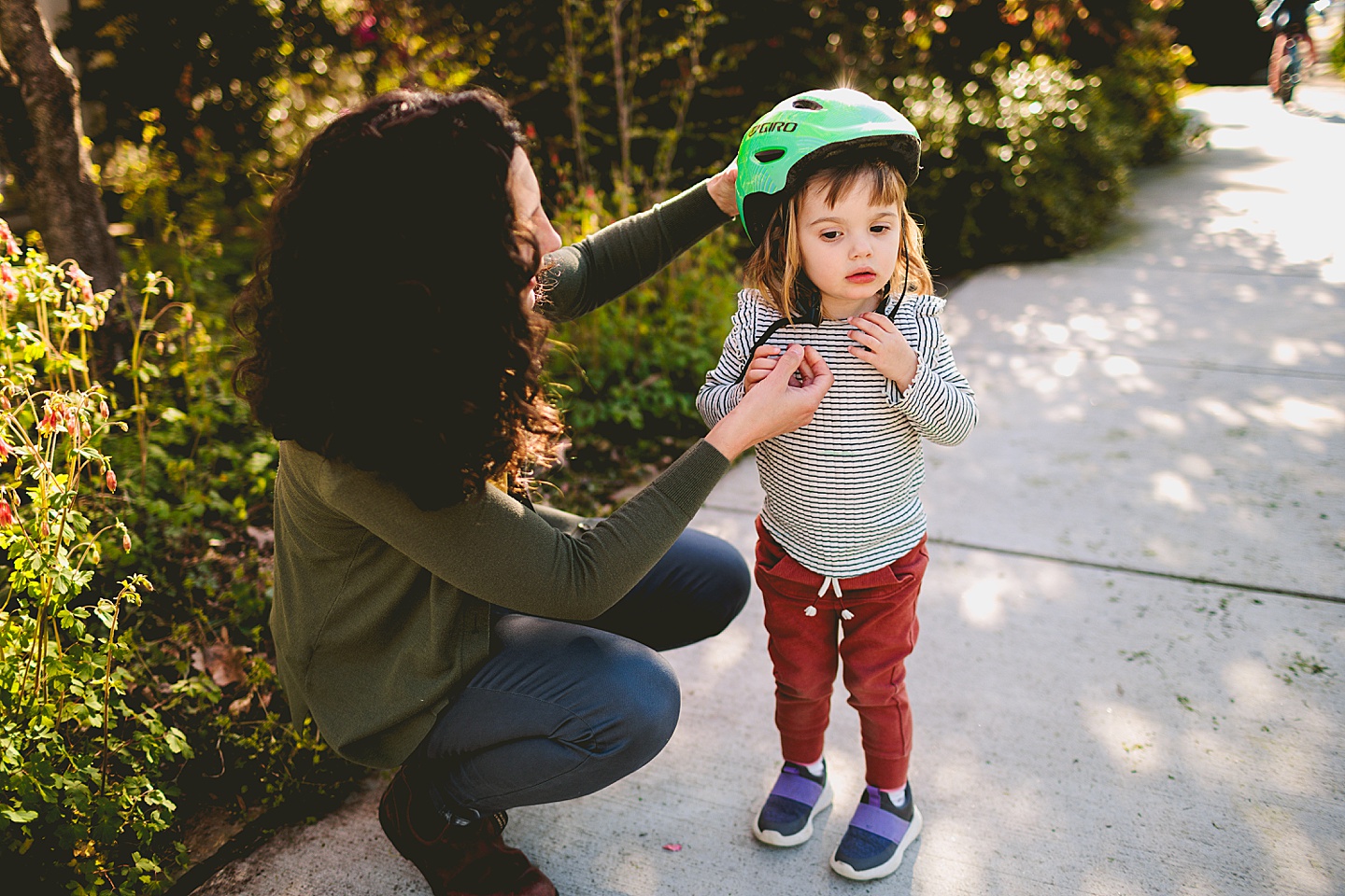 Mom helping girl take off helmet