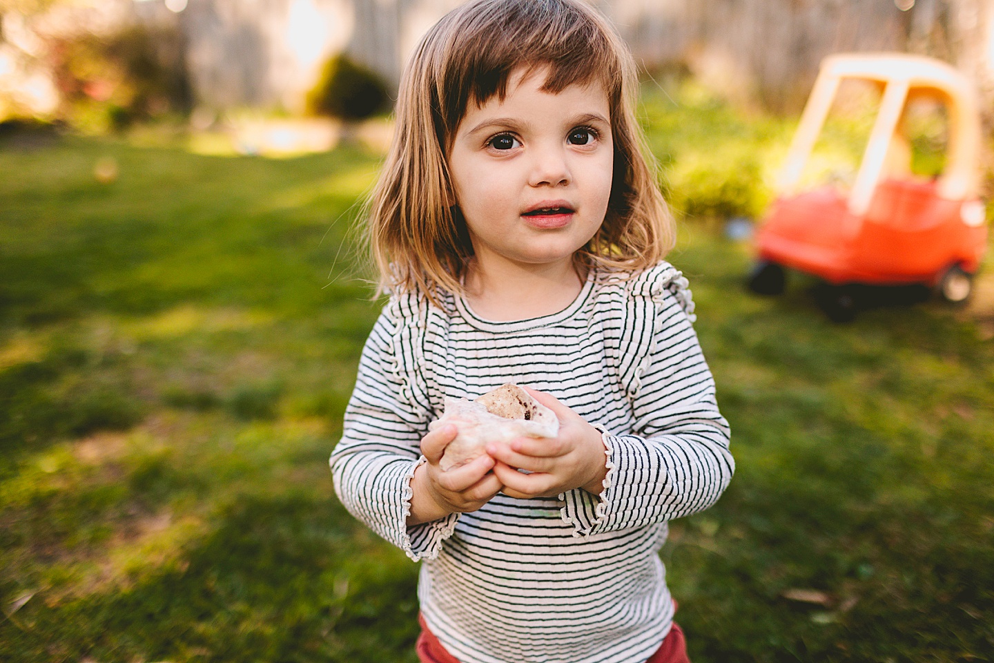 Girl holding a seashell in the backyard